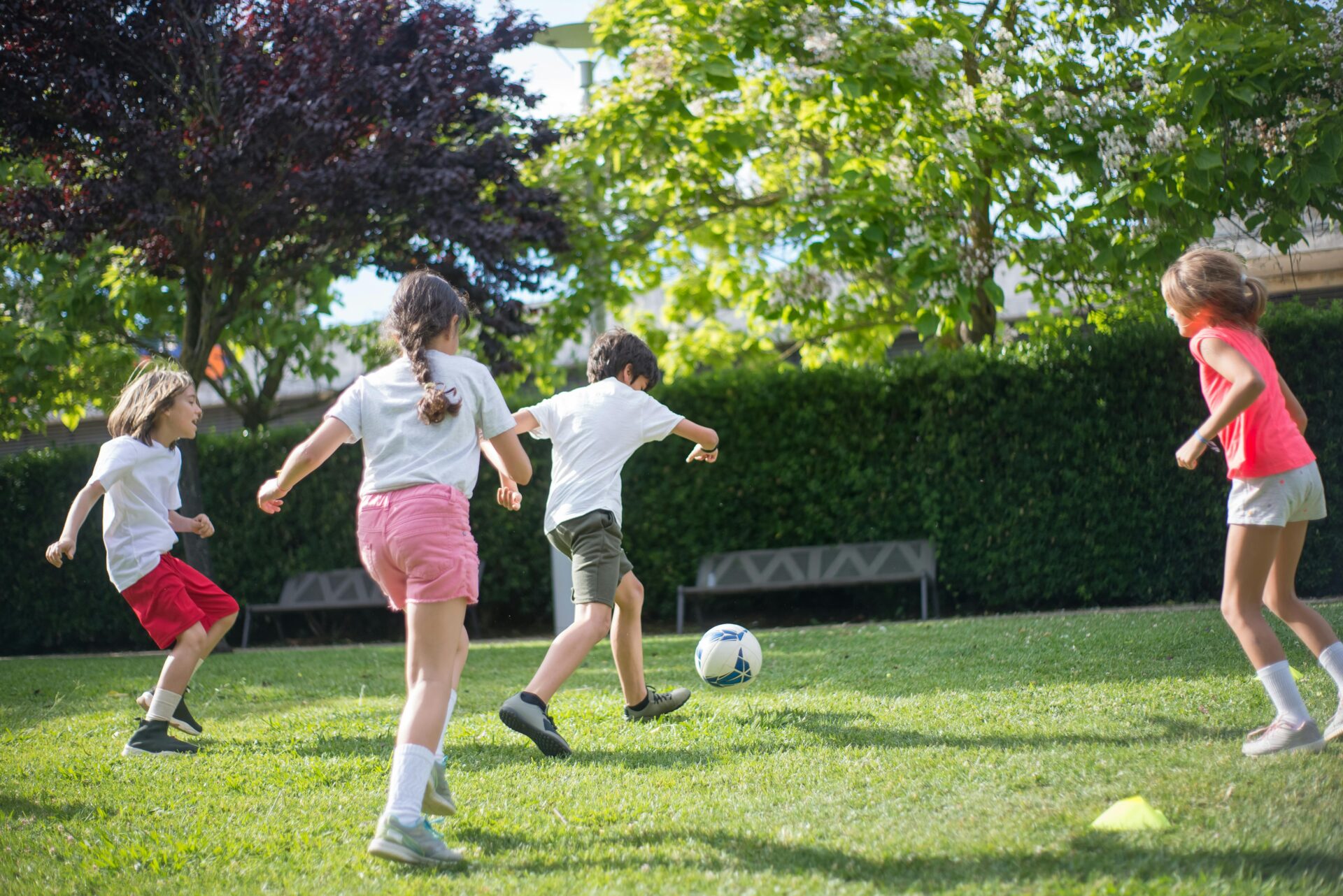 4 kids playing soccer outside